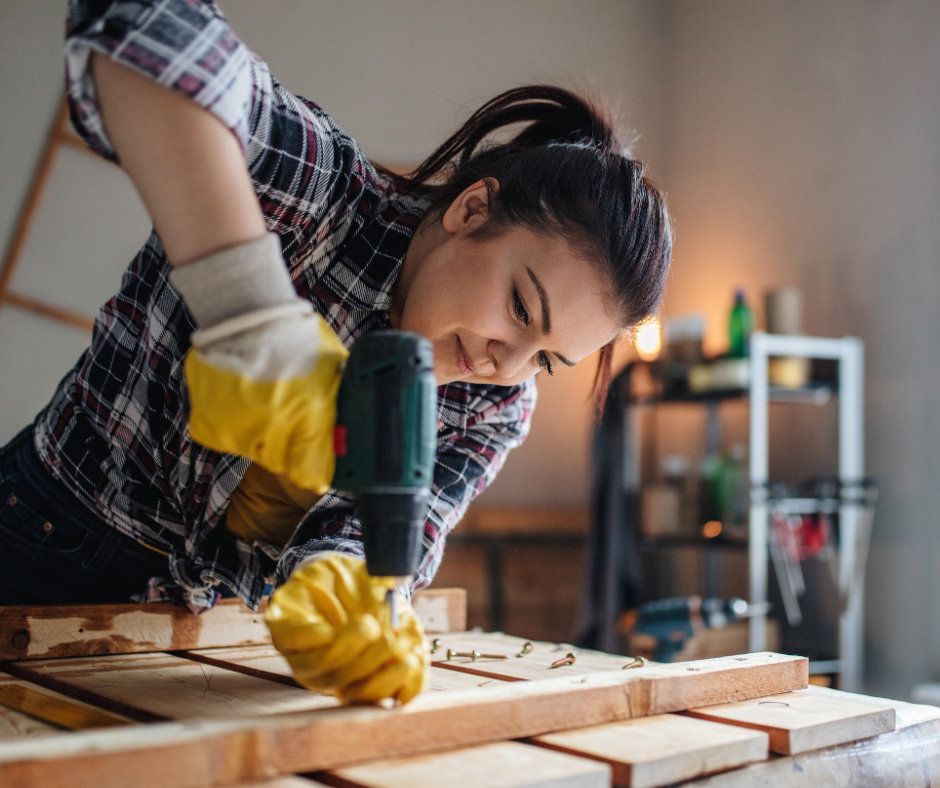 woman drilling into board
